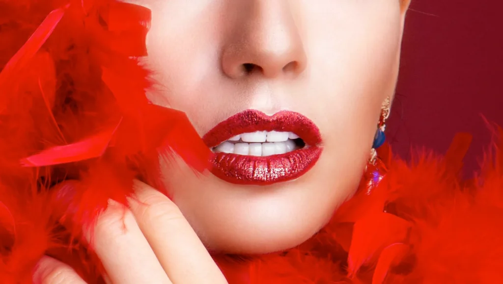Frau mit roter Federboa und roten Lippen