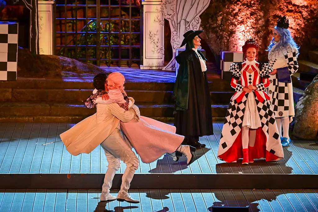 Pärchen Umarmt sich und König und Königin stehen im Hintergrund