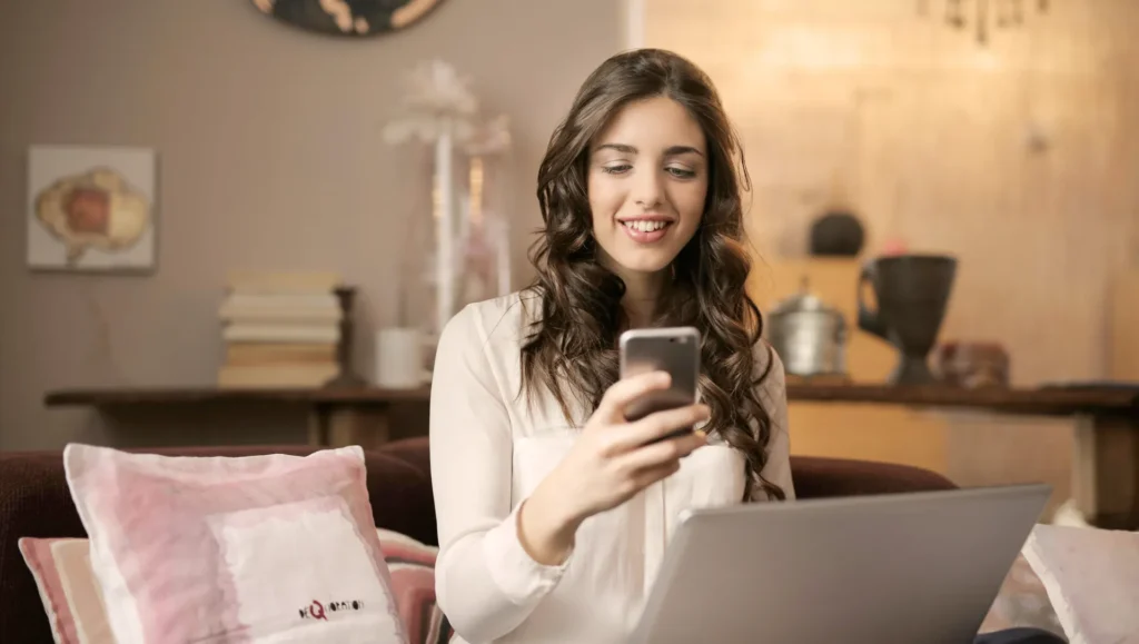 Frau mit Handy und Laptop