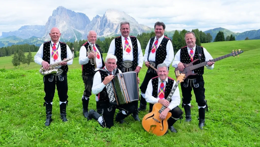 7 Männer auf einer Almwiese mit Insturmenten und bayrischer Tracht
