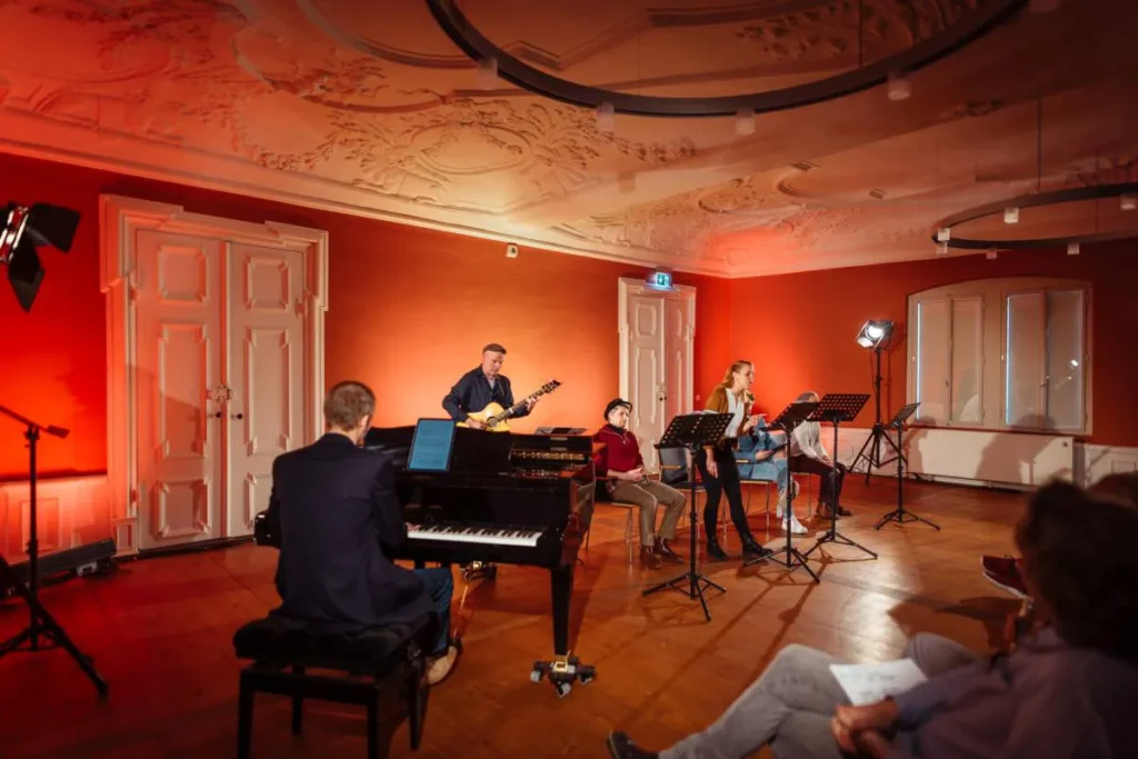 Band in einem barocken Raum mit Klavier und Musik