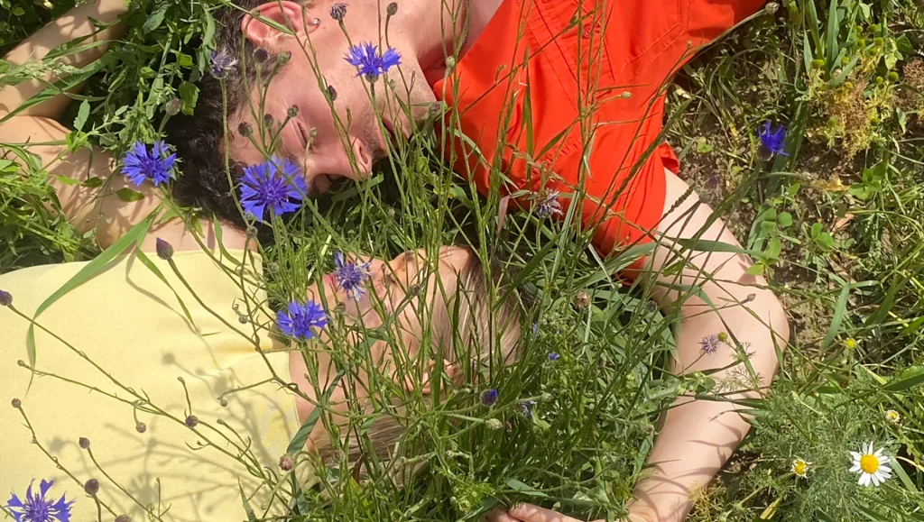 Ein Mann und eine Frau liegen in einer Blumenweise